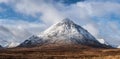 Beautiful iconic landscape Winter image of Stob Dearg Buachaille Etive Mor mountain in Scottish Highlands againstd vibrant blue