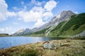 Beautiful and idyllic mountain landscape scenery: Mountain range, lake with clear water and blue cloudy sky Royalty Free Stock Photo