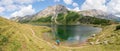 Beautiful and idyllic mountain landscape scenery: Mountain range, lake with clear water and blue cloudy sky; Panorama Royalty Free Stock Photo