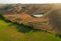 Beautiful idyllic summer landscape of Toscana with many mediterranean plants, hills, fields and pond.