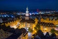 Beautiful illuminated town hall building in Jelenia Gora, Poland surrounded by tenement houses, restaurants and mountains