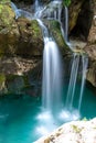 Beautiful image of blurred stream of waterfalls falling over mossy rocks