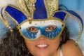 Image of the face of a smiling woman with black curly hair wearing a Venetian mask Royalty Free Stock Photo