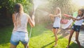 Beautiful image of happy laughing family with children having fun at hot summer day with water guns and garden hose Royalty Free Stock Photo