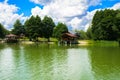 A beautiful image of a landscape from the center of a river surrounded by trees and reeds on the shore against a blue sky in