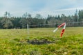 Image of a meadow with wooden poles and wire with red white tape Royalty Free Stock Photo