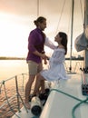 Beautiful image of romantic couple in love looking at each other on yacht at sunset