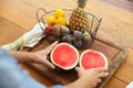 image of someone picking up a cut watermelon from a cutting board at home