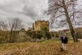 Beautiful image of a woman with her dog enjoying a cold autumn day in front of the ruined Franchimont castle