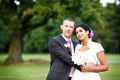 Beautiful indian bride and caucasian groom, in summer park. Happy young woman holding flowers. Young man smiling, Couple Royalty Free Stock Photo