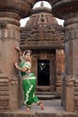 Beautiful indian girl dancer of Indian classical dance Odissi posing in front of Mukteshvara Temple, Bhubaneswar, Odisha, India.