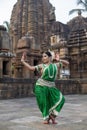 Beautiful indian girl dancer of Indian classical dance Odissi posing in front of Mukteshvara Temple, Bhubaneswar, Odisha, India.Od