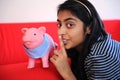 Beautiful Indian girl holding piggybank