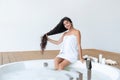 Beautiful Indian girl showing her healthy long hair while sitting on round bubble bath