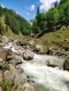 A beautiful Indian Himalayan Mountain valley with scenic water stream flowing through rocks and stones.