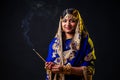 Beautiful indian woman aromatic stick diwali holiday on black background studio