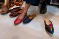 Beautiful Indian woman, trying out her foot for fitting of colorful Rajsathani ladies shoes at shoe store at famous Sardar Market Royalty Free Stock Photo