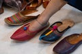 Beautiful Indian woman, trying out her foot for fitting of colorful Rajsathani ladies shoes at shoe store at famous Sardar Market Royalty Free Stock Photo