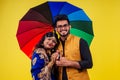 Beautiful indian woman in traditional blue india sari and romantic man in kurta together standing under multicolor Royalty Free Stock Photo