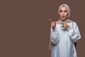 Beautiful indonesian woman wearing hijab is pointing to the front side