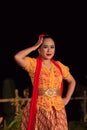 Beautiful Indonesian women wearing an orange traditional dance costume called kebaya when dancing a danced called jaipong