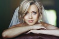 Beautiful innocent blonde bride leaning against chair closeup Royalty Free Stock Photo