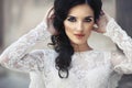 Beautiful innocent brunette bride in white dress posing near church closeup Royalty Free Stock Photo