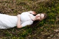 Beautiful innocent woman in white dress lying on the grass Royalty Free Stock Photo