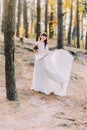 Beautiful innocent young brunette bride in gorgeous long white dress at forest Royalty Free Stock Photo