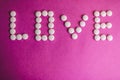 Beautiful inscription love made from white round smooth medical pills, vitamins, antibiotics and copy space Royalty Free Stock Photo