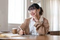 A beautiful and inspired Asian woman working remotely at a coffee shop, using her digital tablet Royalty Free Stock Photo