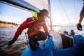 Beautiful inspiring shot of action adventure of sailor or captain on yacht or sailboat attaching big mainsail or