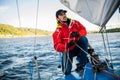Beautiful inspiring shot of action adventure of sailor or captain on yacht or sailboat attaching big mainsail or
