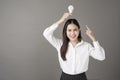 Beautiful intelligent woman is holding light bulb in studio