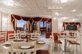 Beautiful interior of an Indian restaurant with red curtains and white chairs