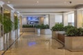 Beautiful interior of Radisson Resort with beige marble flooring and green plants on both sides of lobby.
