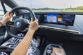 Beautiful interior view of electric car BMW iX40 on road. Woman driver in vehicle.