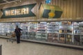 Beautiful interior view of an ICA supermarket. Woman buying dairy products from refrigerators of supermarket.