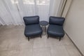 A beautiful interior view of two chairs with a table between them in the corner of a hotel room. Royalty Free Stock Photo