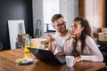 Beautiful interracial couple using laptop computer at home surfing the internet Royalty Free Stock Photo