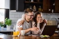 Beautiful interracial couple using laptop computer at home surfing the internet having good time Royalty Free Stock Photo