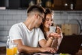 Beautiful interracial couple using laptop computer at home surfing the internet having good time Royalty Free Stock Photo