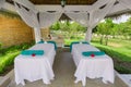 Beautiful inviting view of cozy comfortable massage beds standing inside gazebo in tropical garden