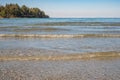 Beautiful island with sand and trees at the ocean. Beach sand and ocean waves sea water foam texture background Royalty Free Stock Photo