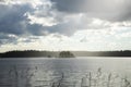 A beautiful island with trees on the huge lake. Rain at sunset makes the sky shine Royalty Free Stock Photo