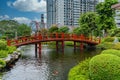 Beautiful Japanese garden with a red bridge crossing the Koi fish pond Royalty Free Stock Photo