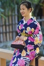 Beautiful Japanese Geisha Girl Posing in Floral Silk Kimono in Traditional Environment in Kyoto