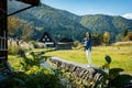 Beautiful Japanese girl with a background of Shirakawago village during autumn with a triangle house, rice field, and pine mountai Royalty Free Stock Photo