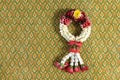 Beautiful jasmine garland onThai style fabric pattern background.