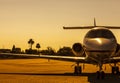 Luxury private jet is parked on an airfield during gorgeous golden sunset